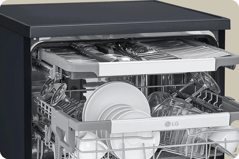 Spatulas, spoons, forks and knives arranged in the dishwasher's third rack.