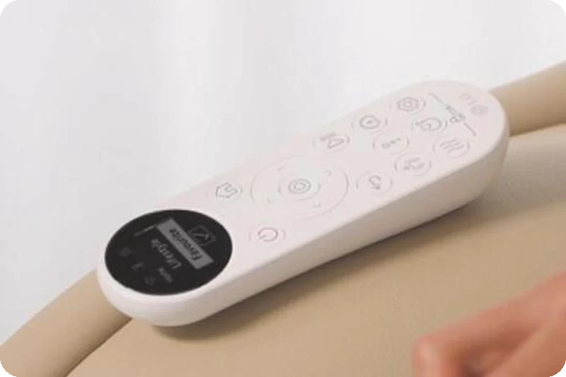 Wireless OLED remote control magnetically attached to the LG Arte massage chair.