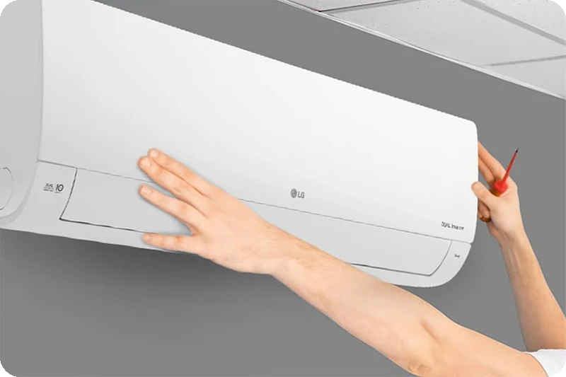 An installer fitting an LG split air conditioner.