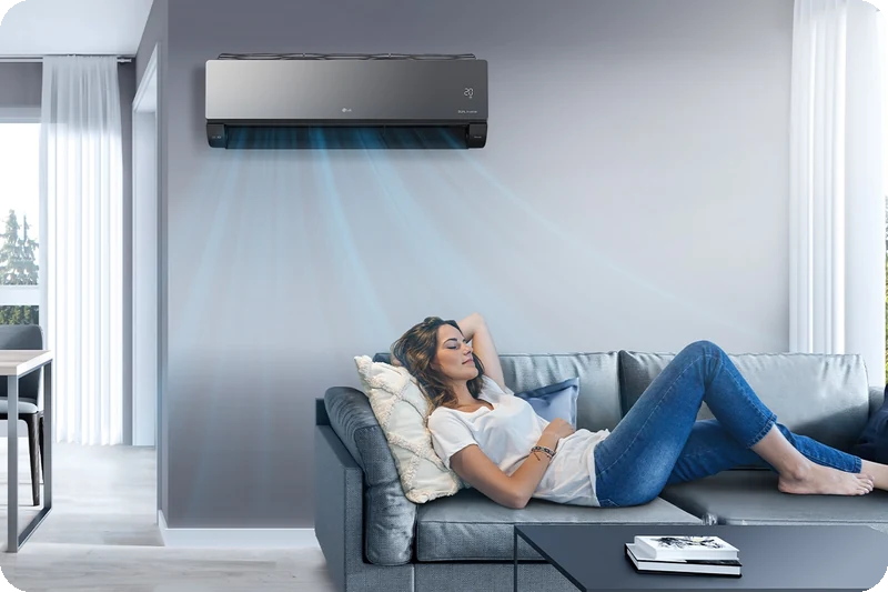 A person resting comfortably while the LG ARTCOOL air conditioner operates quietly.