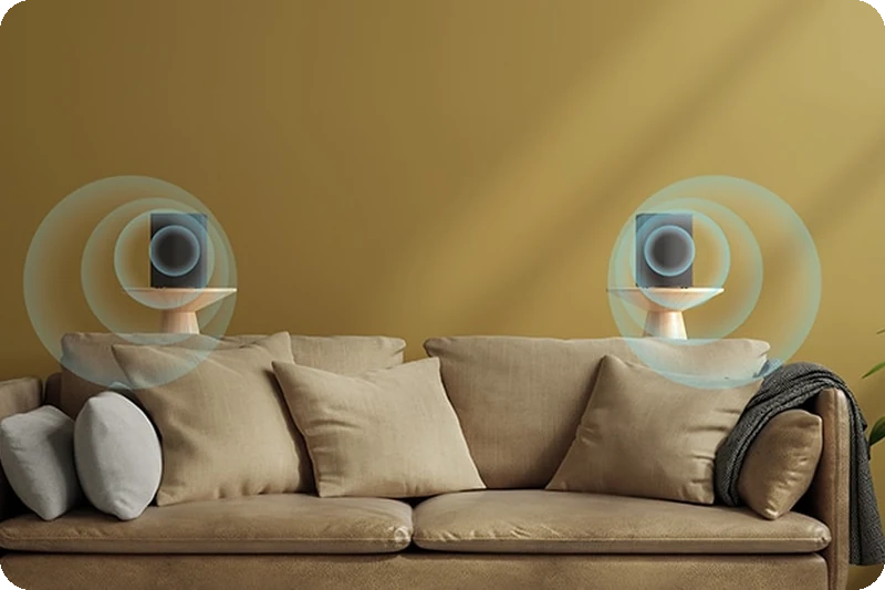 Two LG S60TR rear speakers creating dimensional sound behind a sofa.