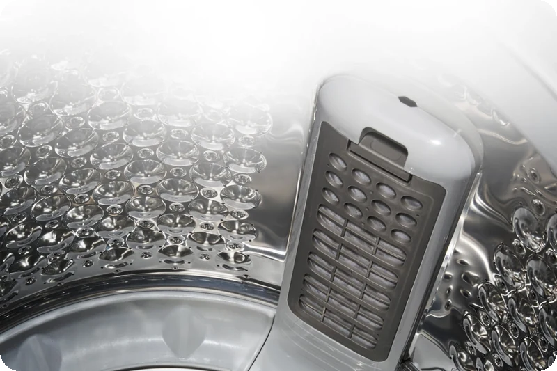 LG top-load washer drum showing its large lint filter and stainless-steel design.