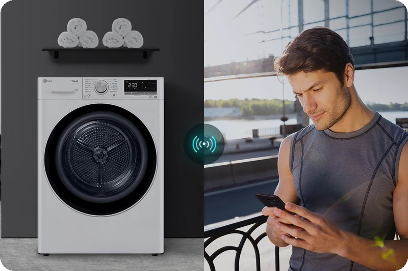 A man using the LG ThinQ app to control the dryer remotely.