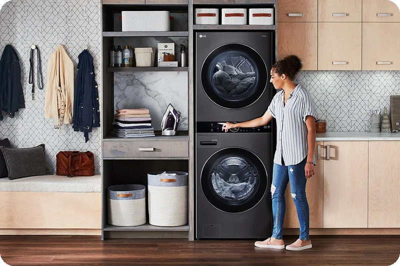 Black LG WashTower installed neatly between shelving and cabinetry.