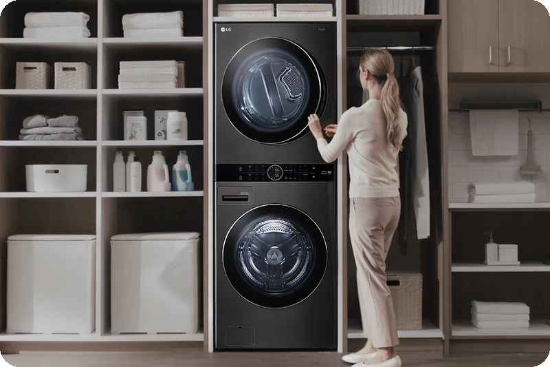 Woman comfortably operating the centrally positioned LG WashTower control panel.